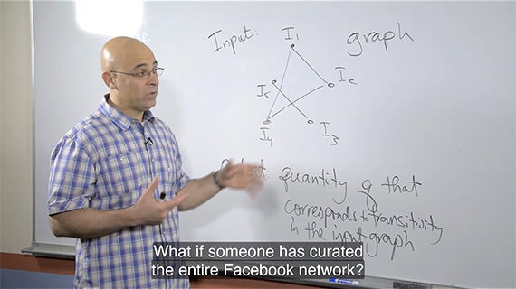 A man is positioned in front of a whiteboard, which features a diagram, likely explaining a concept or idea.